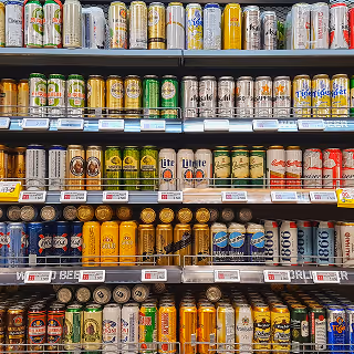 Store shelves fully stocked with a wide variety of canned beers arranged in rows, showcasing different brands and colorful packaging.