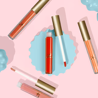 Flat lay of five lip gloss tubes with gold caps in shades of red, coral, and nude, arranged on a pink and blue background with scalloped and wavy textures.