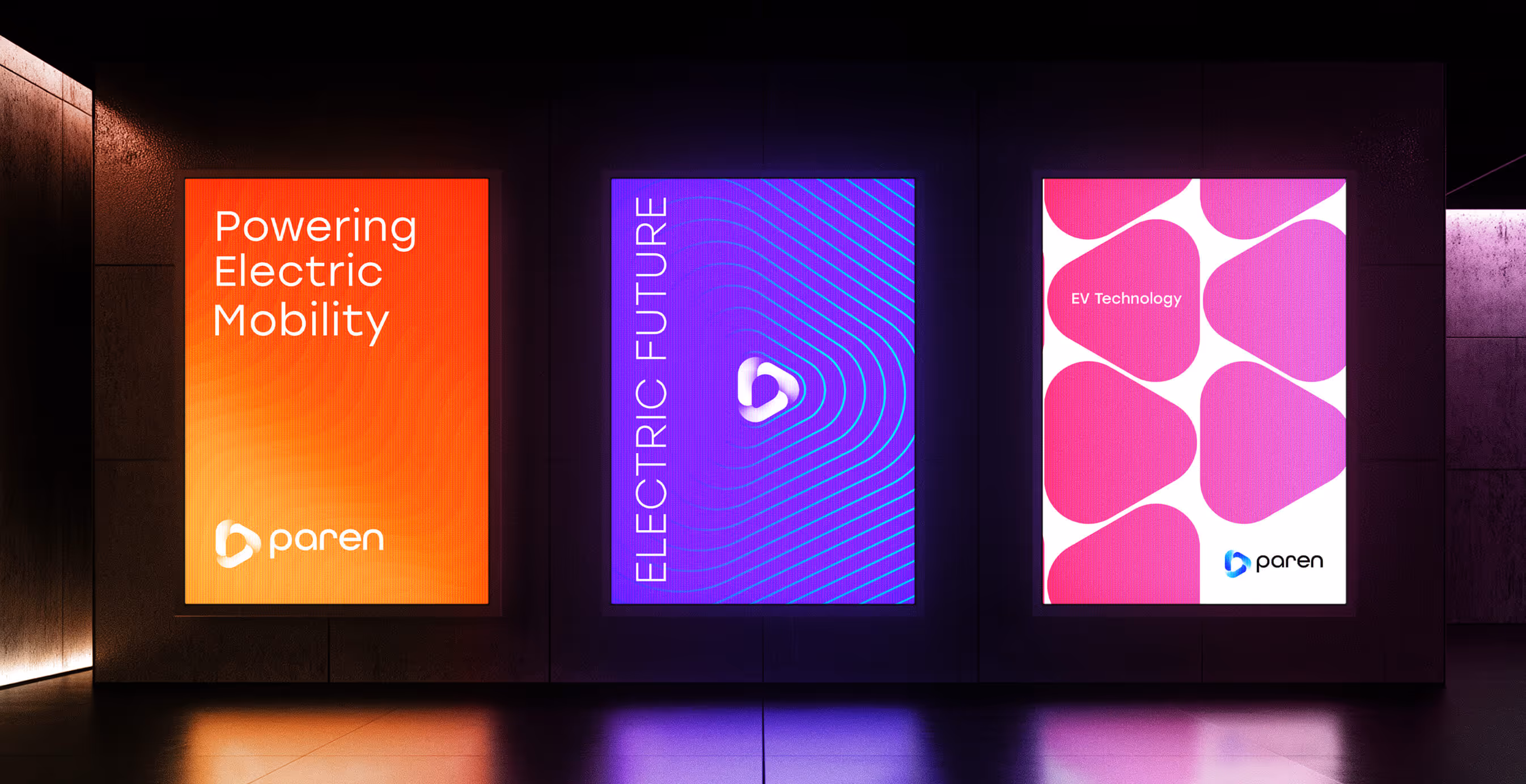 Three illuminated posters in a dark hallway. Left: orange with text ‘Powering Electric Mobility’ and Paren logo. Center: purple with waves and ‘Electric Future.’ Right: pink geometric pattern with ‘EV Technology’ and Paren logo.