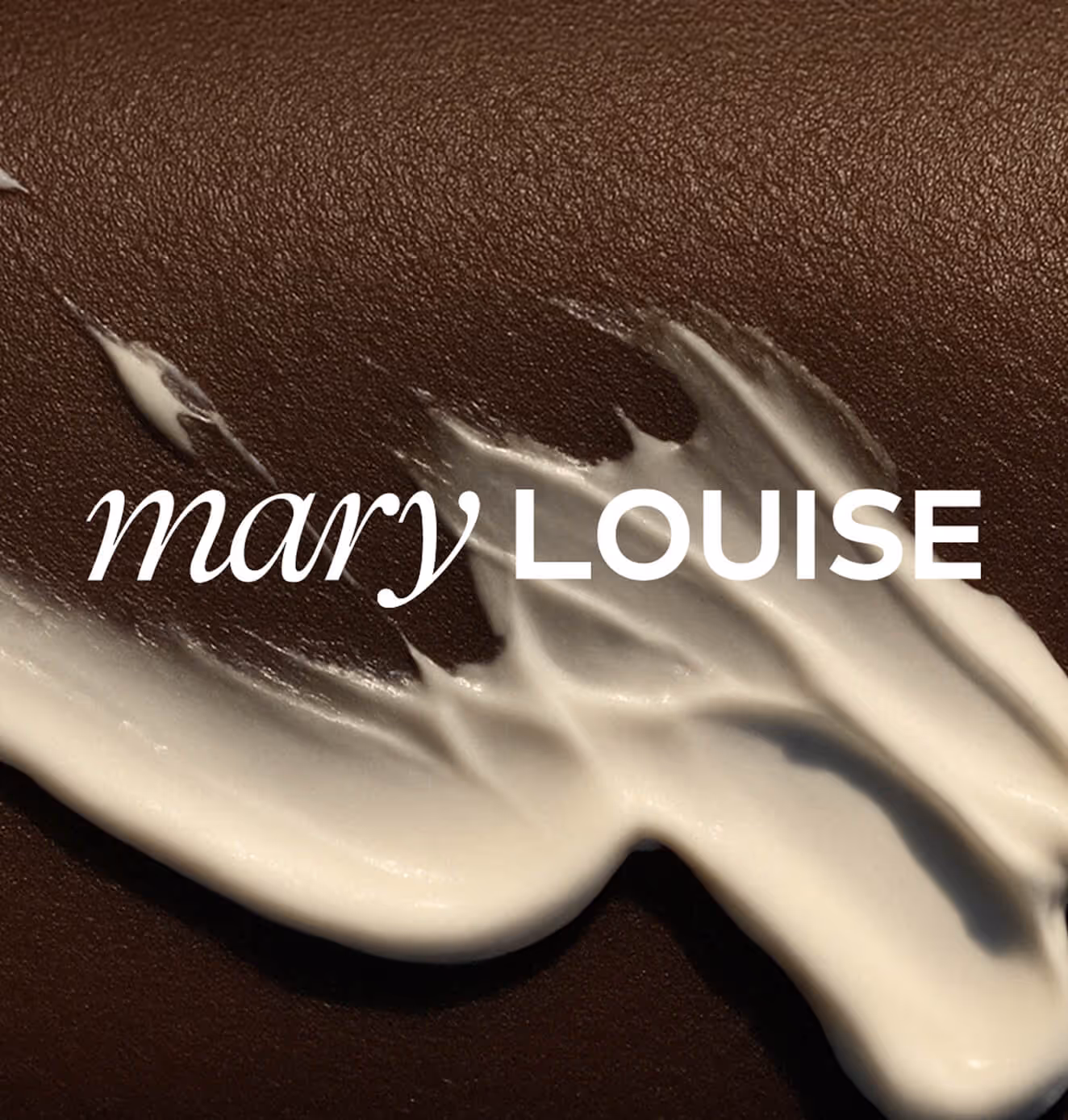 Close-up of Mary Louise logo placed over a textured brown background with a white cream smear, highlighting luxury skincare branding.