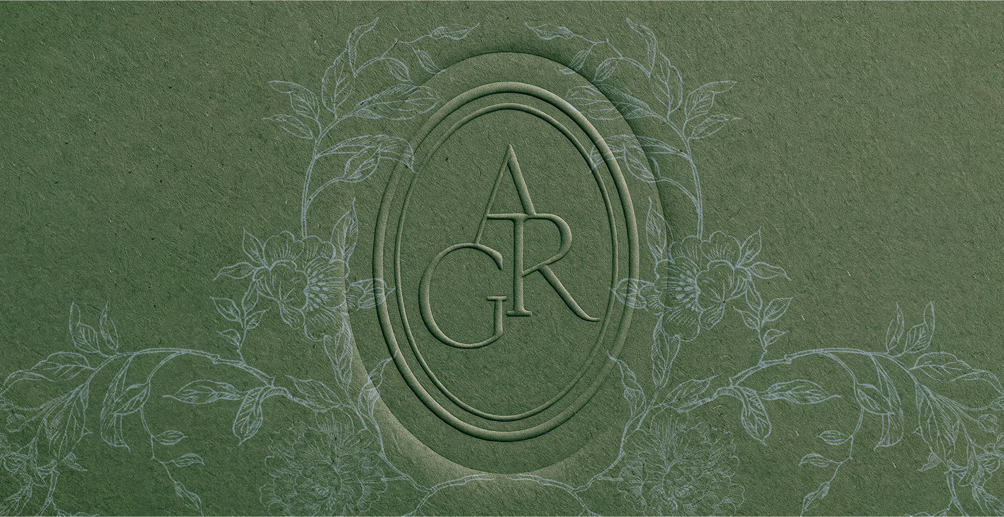 Embossed logo design featuring the initials “ARG” inside an oval frame, surrounded by delicate floral line art on textured green paper.