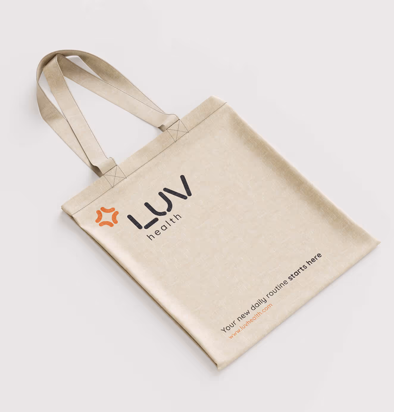 Beige LUV Health tote bag with black logo and tagline “Your new daily routine starts here” printed at the bottom.