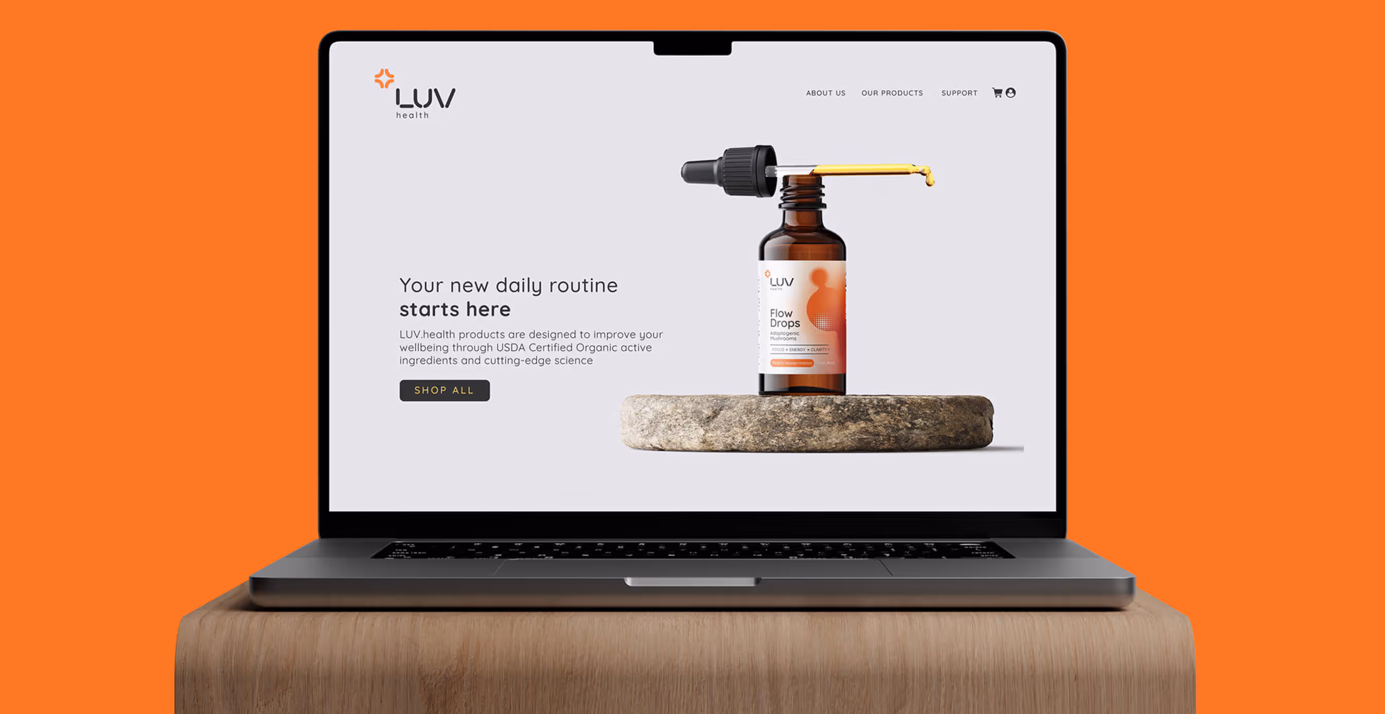 Laptop screen showing LUV Health website featuring Flow Drops supplement bottle on a stone base, with tagline “Your new daily routine starts here.”