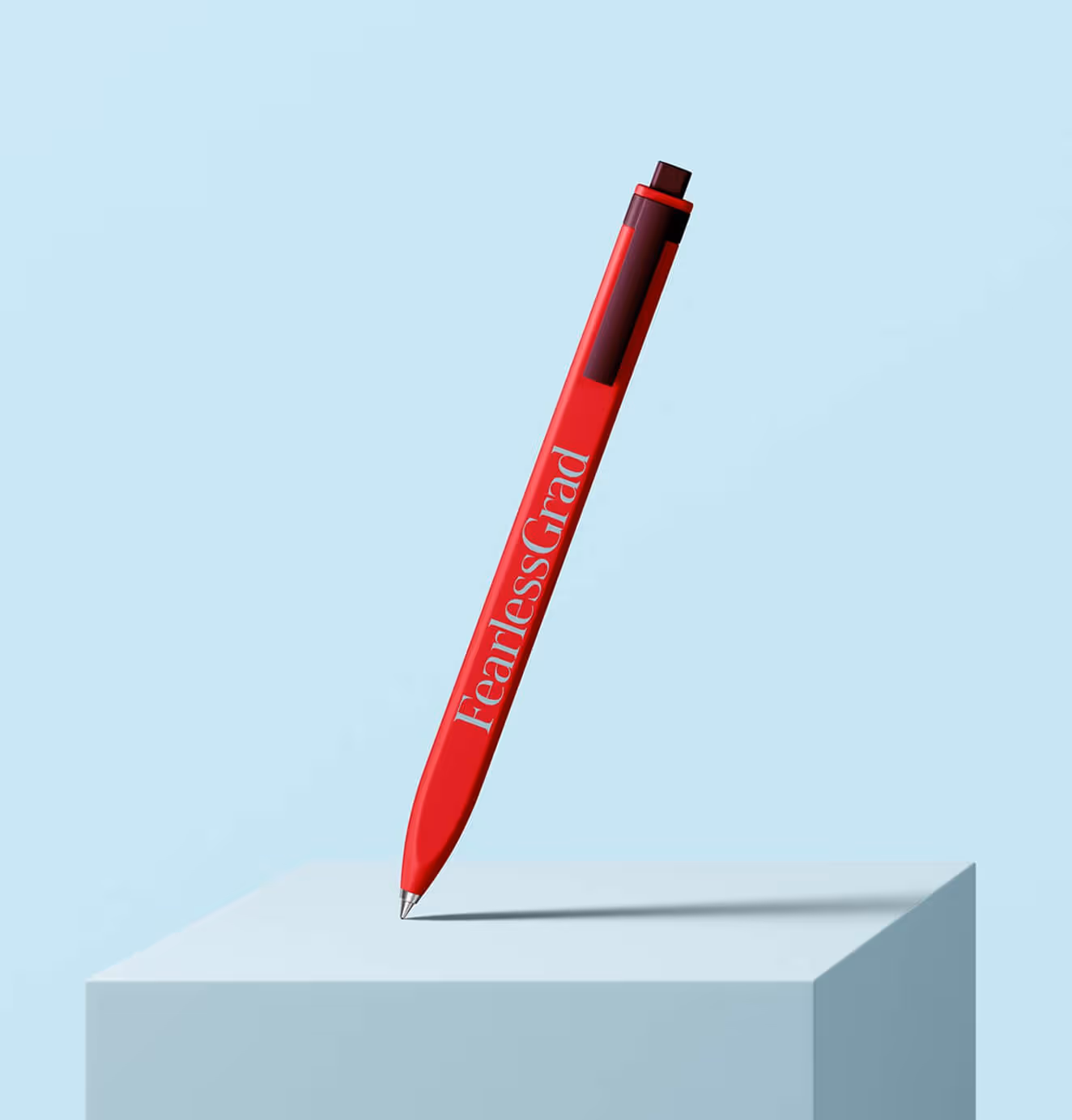 Red Fearless Grad-branded pen displayed upright on a light blue block background.