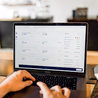 Close-up of a laptop screen with a financial dashboard displaying earnings and user metrics, highlighting ad performance insights.