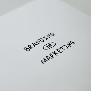 A white paper with the handwritten words “Branding and Marketing,” highlighting the central relationship between branding strategies and marketing success.
