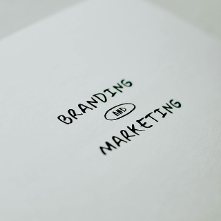Minimalist white paper with the words “Branding and Marketing” typed in simple black font, centered on the page.