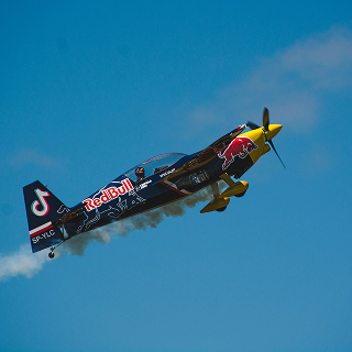 A Red Bull-branded stunt plane mid-flight, symbolizing high-energy brand positioning and unique market presence.