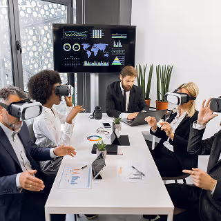Group of business professionals in a meeting room wearing VR headsets, engaged in a virtual collaboration session with data dashboards on a large screen.