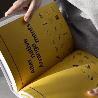 A yellow brand guideline book open to a spread showcasing “Alternative Arrangements” of logo designs, with a grid of black logo variations and text layout examples.
