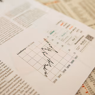 Close-up of a printed magazine page showing a line graph with stock market performance data and statistics.