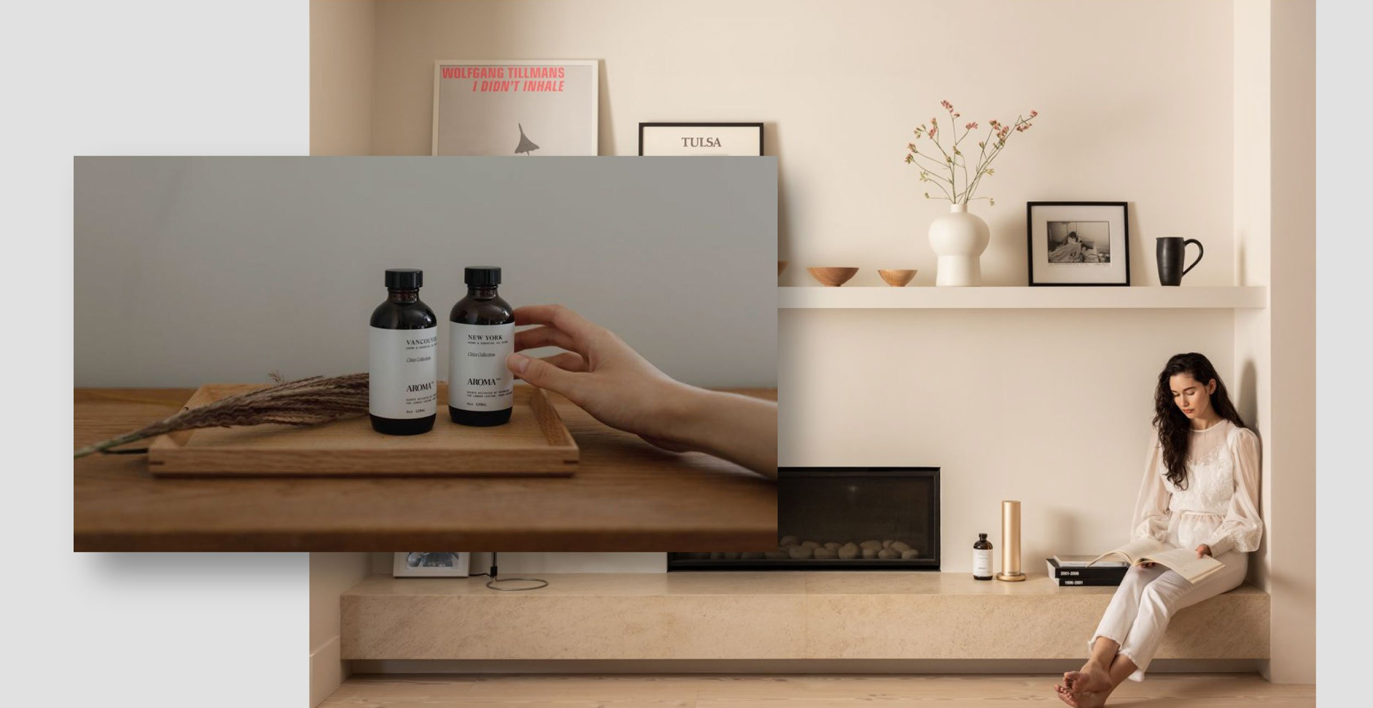 Woman reading in a modern living space while Aromatech essential oils sit on a wooden tray in the foreground.