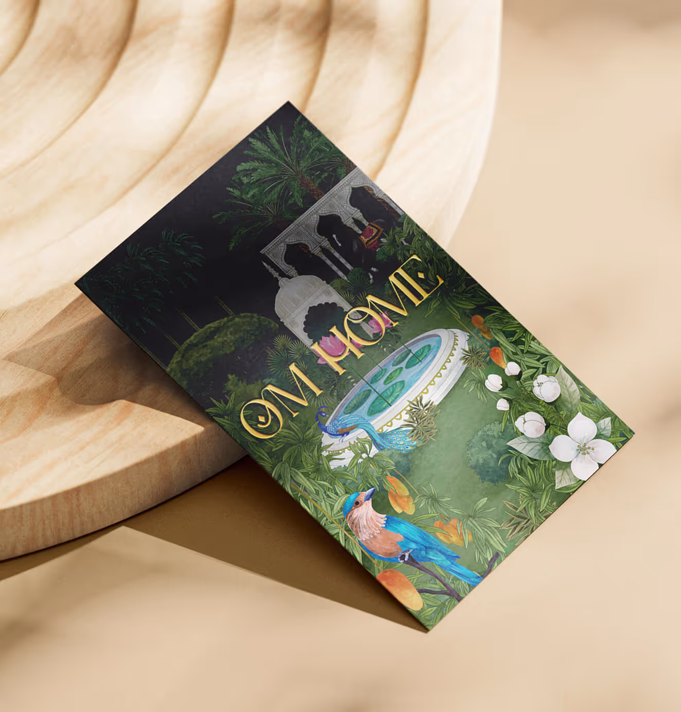 OM Home brochure with detailed illustration of a South Asian-inspired garden scene, including peacocks, trees, and domed architecture.
