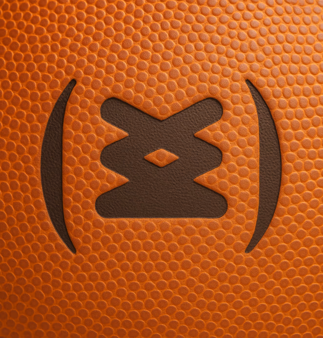 Macro shot of a basketball’s pebbled leather surface featuring the Sneakertopia logo stamped in black.