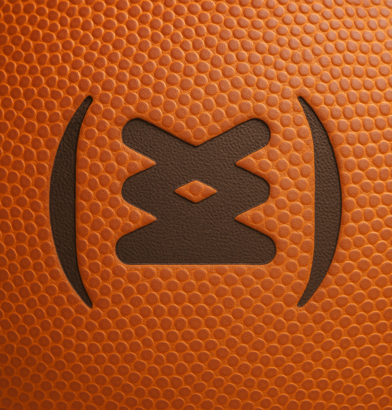 Macro shot of a basketball’s pebbled leather surface featuring the Sneakertopia logo stamped in black.