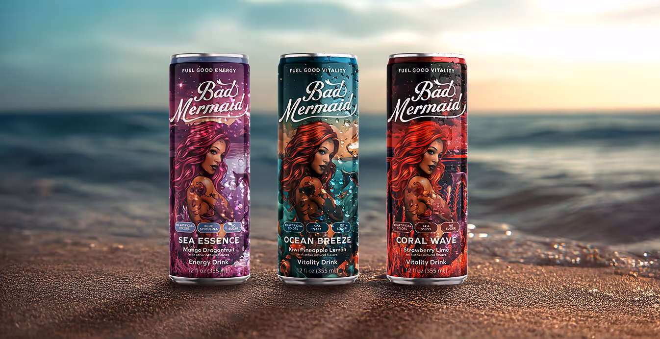 Three Bad Mermaid vitality and energy drink cans displayed on the sand with the ocean in the background. Flavors include Sea Essence (Mango Dragonfruit), Ocean Breeze (Kiwi Pineapple Lemon), and Coral Wave (Strawberry Lime).