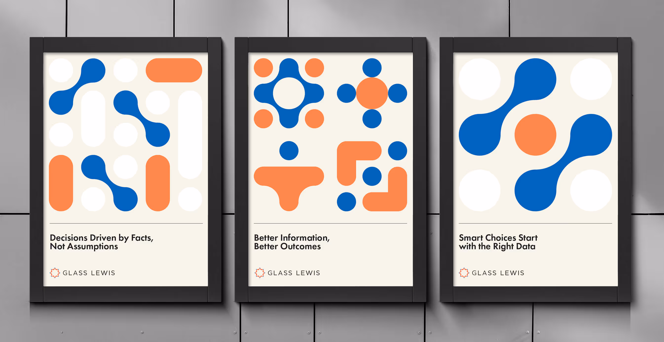 Three framed Glass Lewis posters with bold geometric patterns in blue and orange. The posters read: ‘Decisions Driven by Facts, Not Assumptions,’ ‘Better Information, Better Outcomes,’ and ‘Smart Choices Start with the Right Data.’