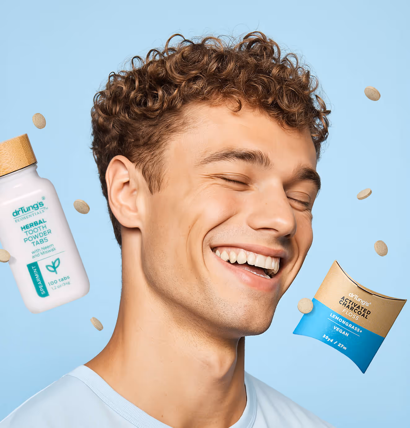 Smiling man with bright teeth on a light blue background, surrounded by floating DrTung’s herbal tooth powder tabs and packaging.