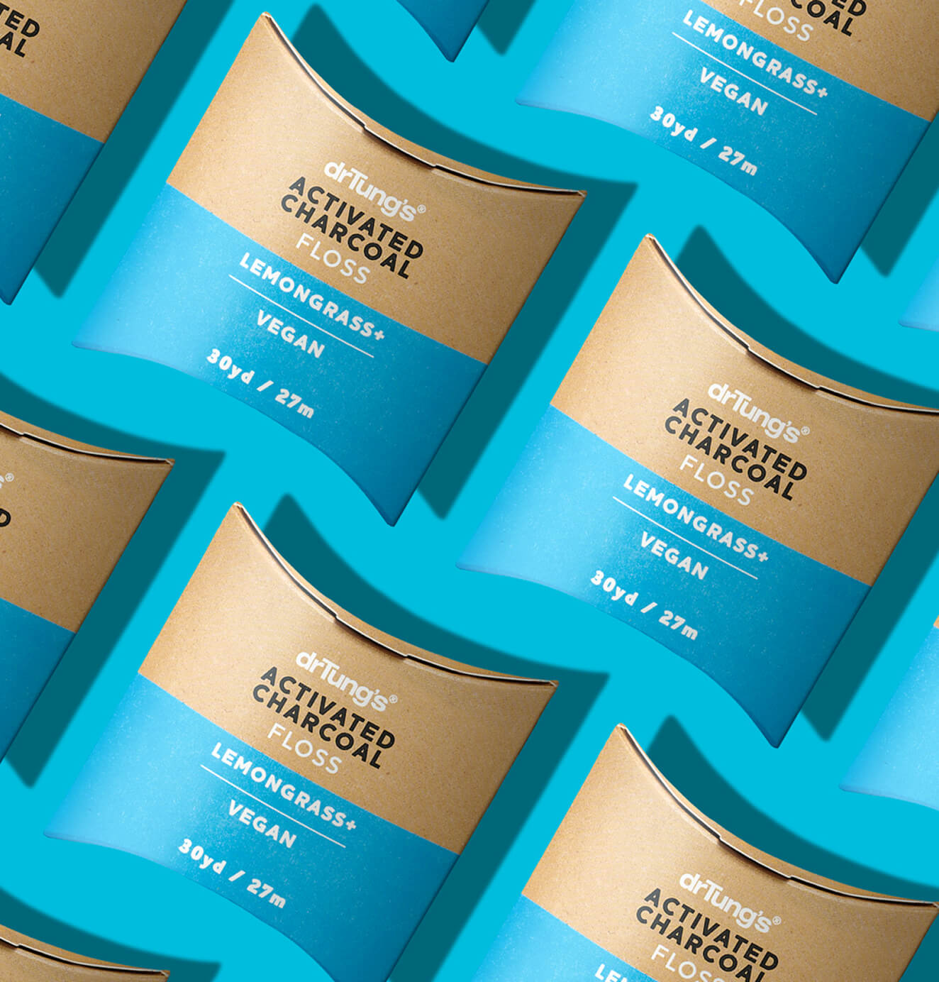 Pattern of DrTung’s Activated Charcoal Floss in brown and blue packaging, arranged diagonally on a bright blue background.