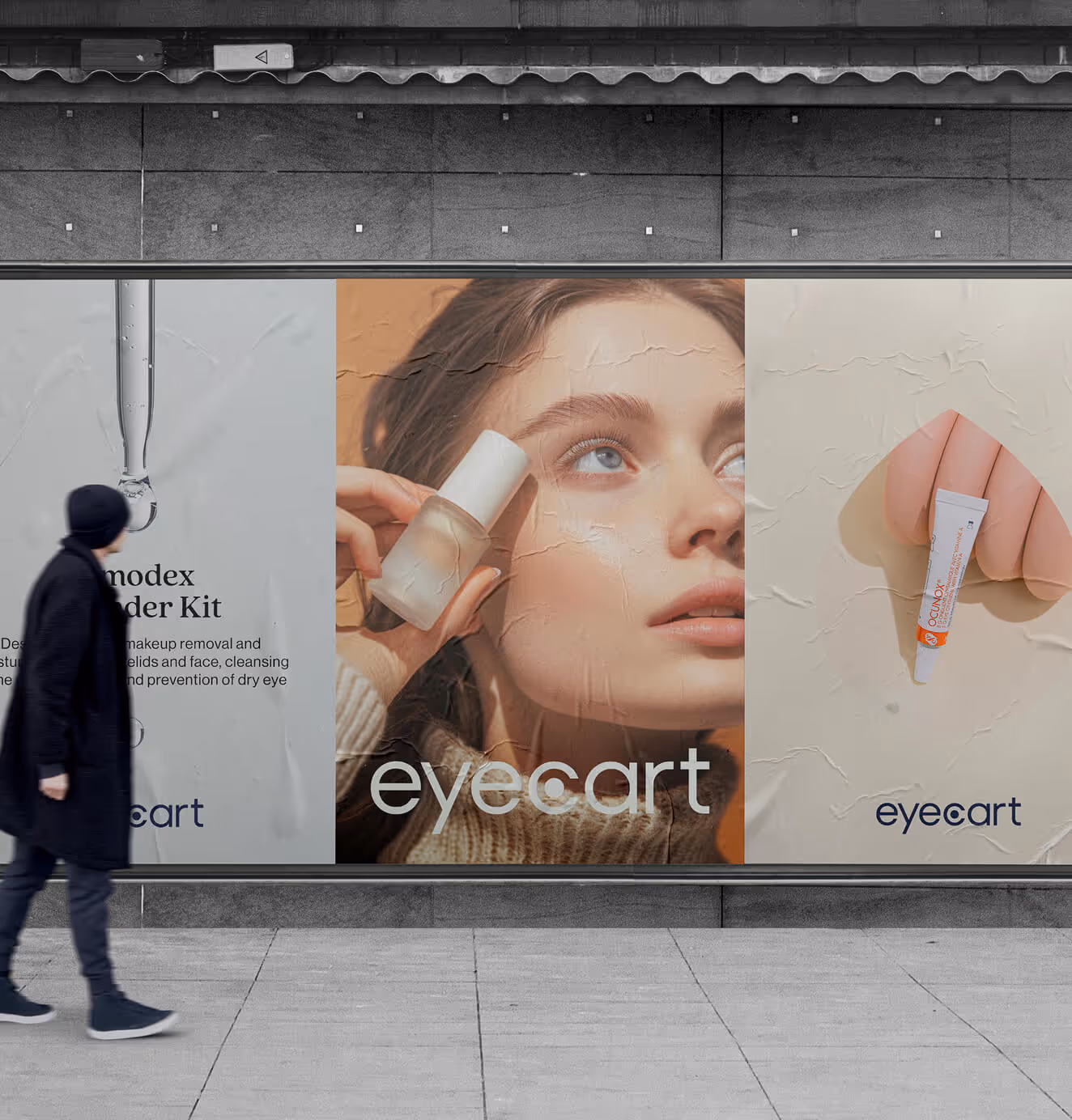 A person walks past large Eyecart posters on a city wall, featuring product photography of eye care serums and creams with clean, modern branding.