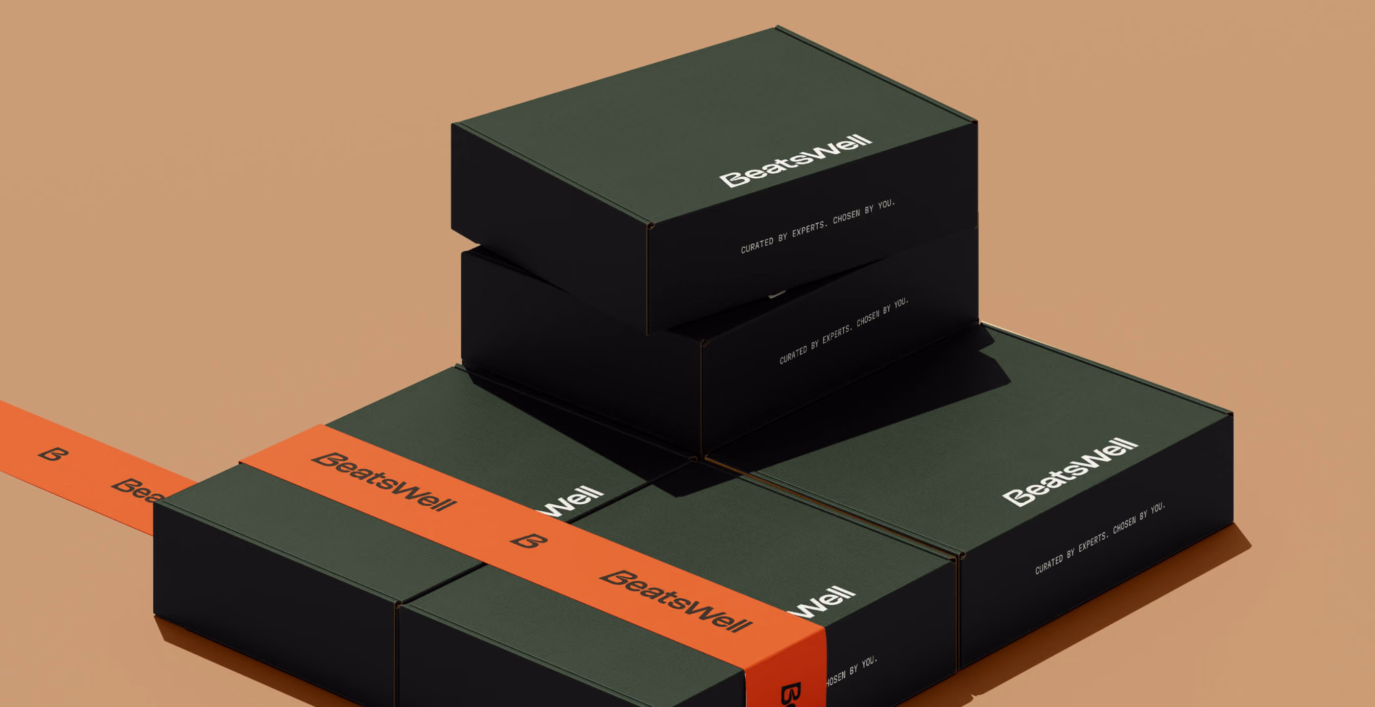 Stacked BeatsWell product boxes in dark green and black with orange branded ribbon, arranged in a clean studio setting.