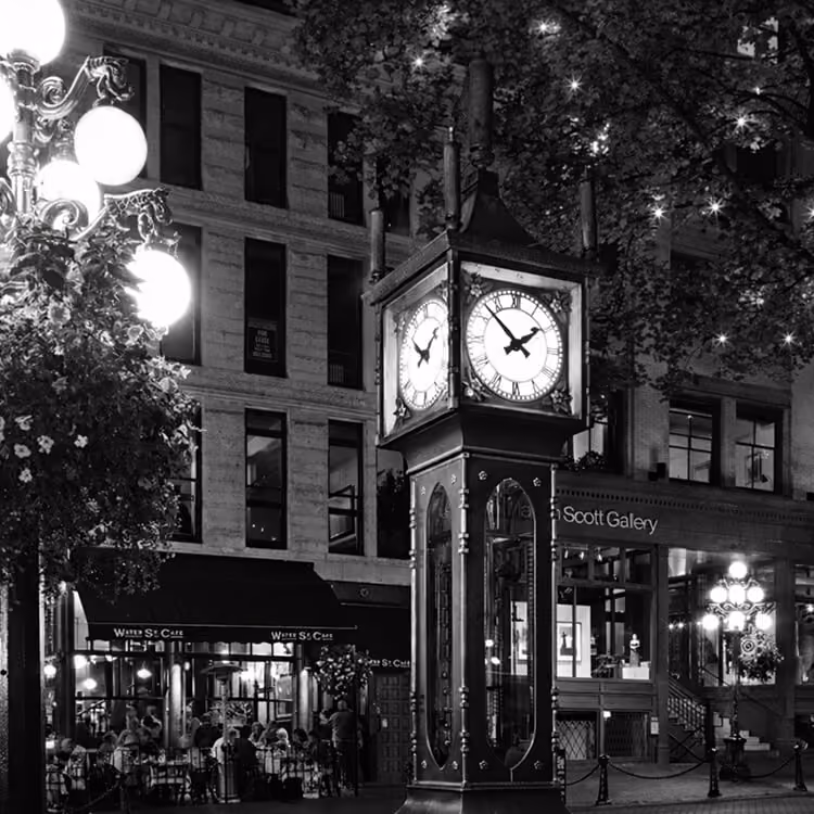 Gastown steam clock in downtown Vancouver at night, surrounded by historic buildings and streetlights.