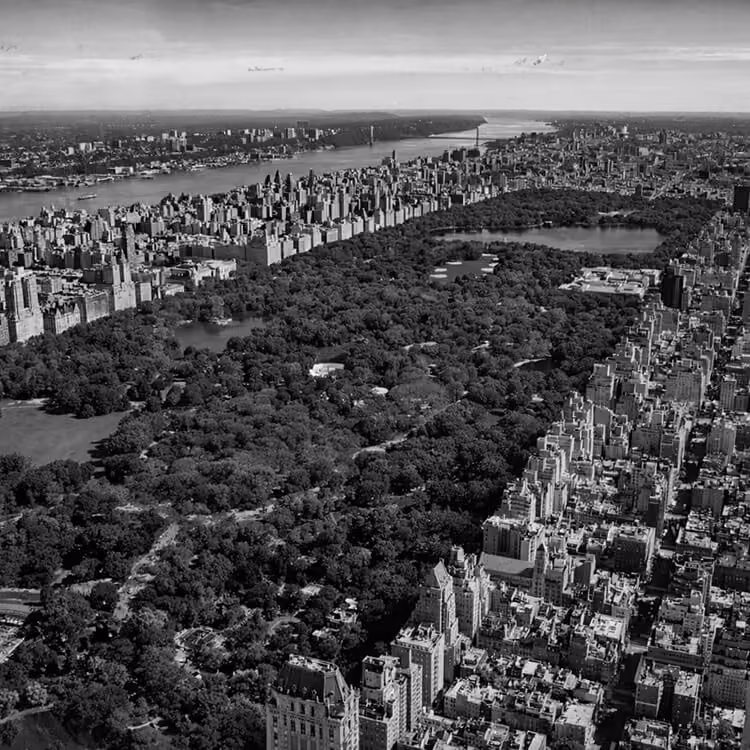 Aerial black and white view of Central Park surrounded by Manhattan skyline and the Hudson River in New York City.
