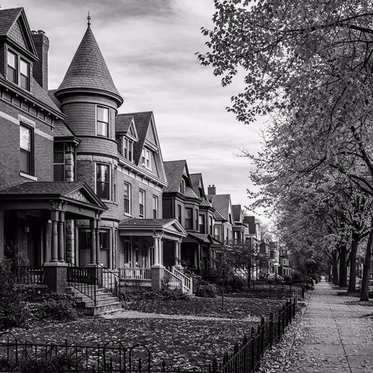 Tree-lined residential street in Buffalo, New York, showcasing historic Victorian homes and neighborhood charm.