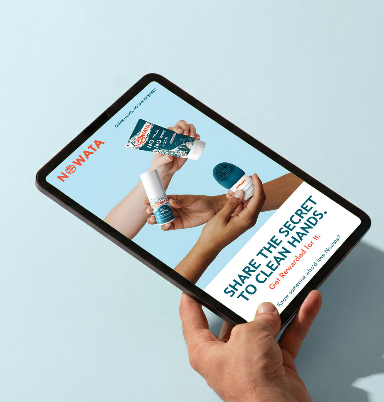 Close-up of hands holding a tablet featuring NOWATA products and referral messaging encouraging users to share and get rewarded.