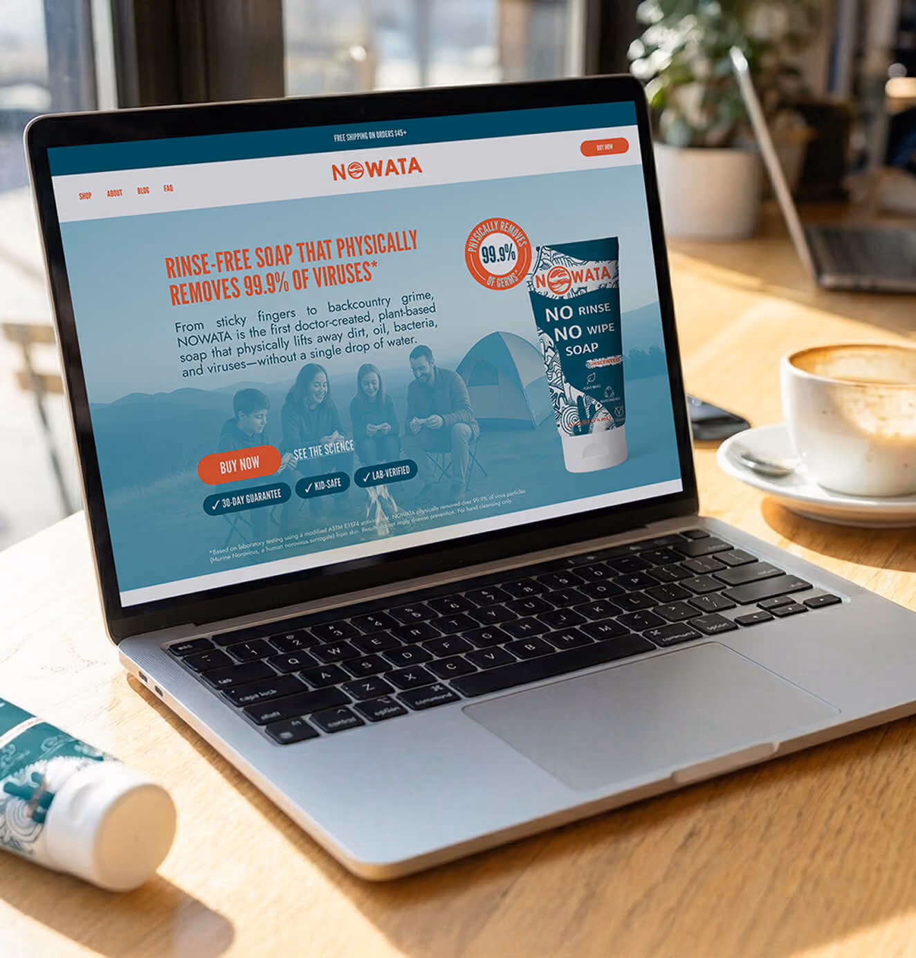 Laptop displaying the NOWATA website featuring rinse-free soap that removes 99.9% of viruses, with buy now and guarantee badges visible.