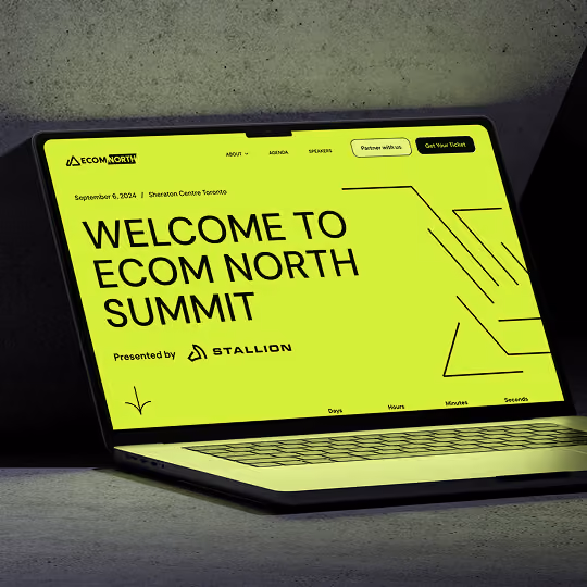 Laptop displaying a bright Ecom North Summit website homepage with bold typography and modern UI design.