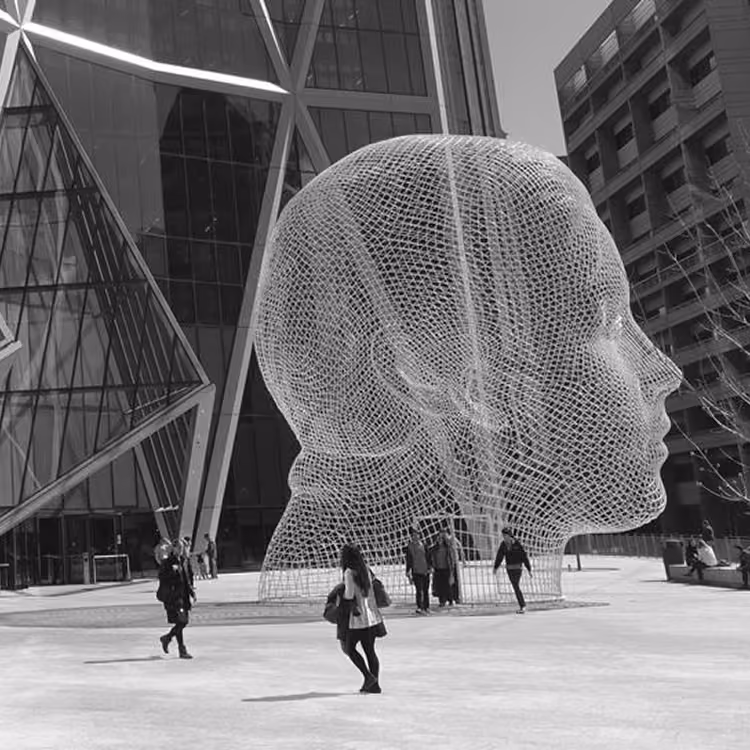 Black and white image of the Wonderland wire sculpture in front of The Bow building with people walking nearby in Calgary.