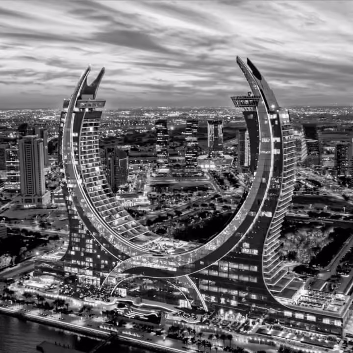 Black and white aerial view of Katara Towers in Lusail with distinctive curved architecture overlooking the city.