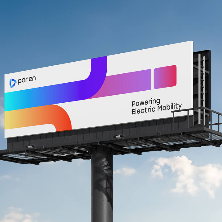 Color image of a large outdoor billboard featuring a modern gradient brand design and the text “Powering Electric Mobility.”