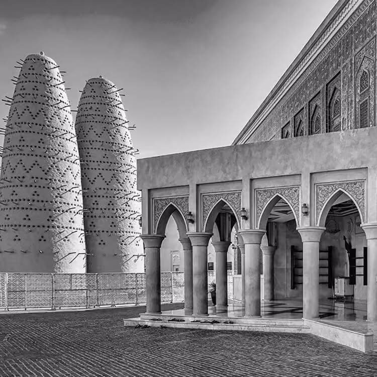 Black and white image of traditional pigeon towers and arched architecture at Katara Cultural Village in Doha, Qatar.