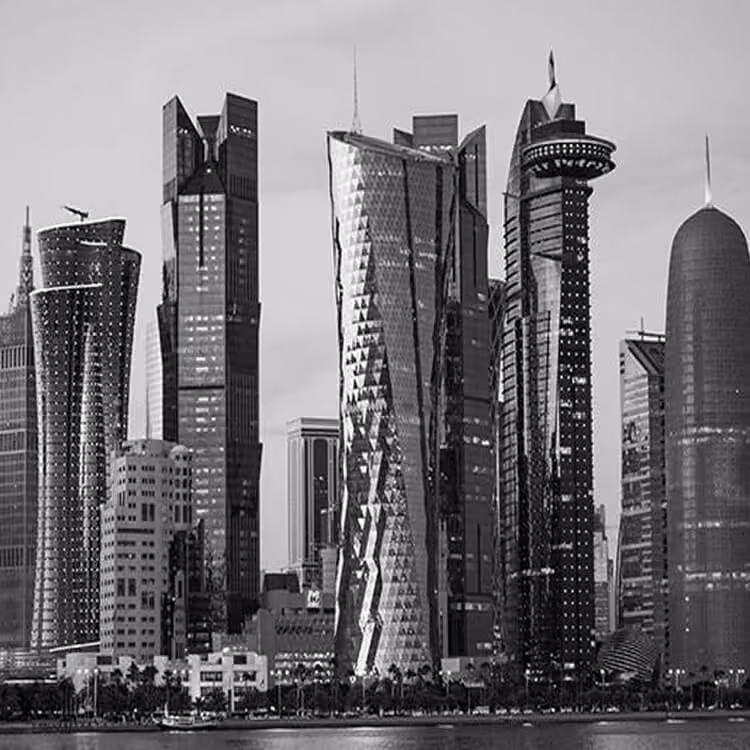 Black and white view of Doha’s West Bay skyline with modern high-rise towers along the waterfront.
