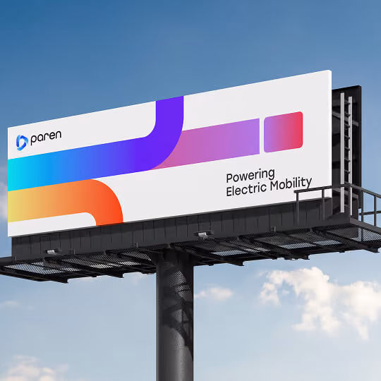 Color image of a large outdoor billboard with a modern gradient brand design and the text “Powering Electric Mobility.”