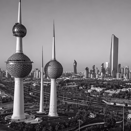 Black and white view of Kuwait Towers with modern skyline and cityscape in Kuwait City.