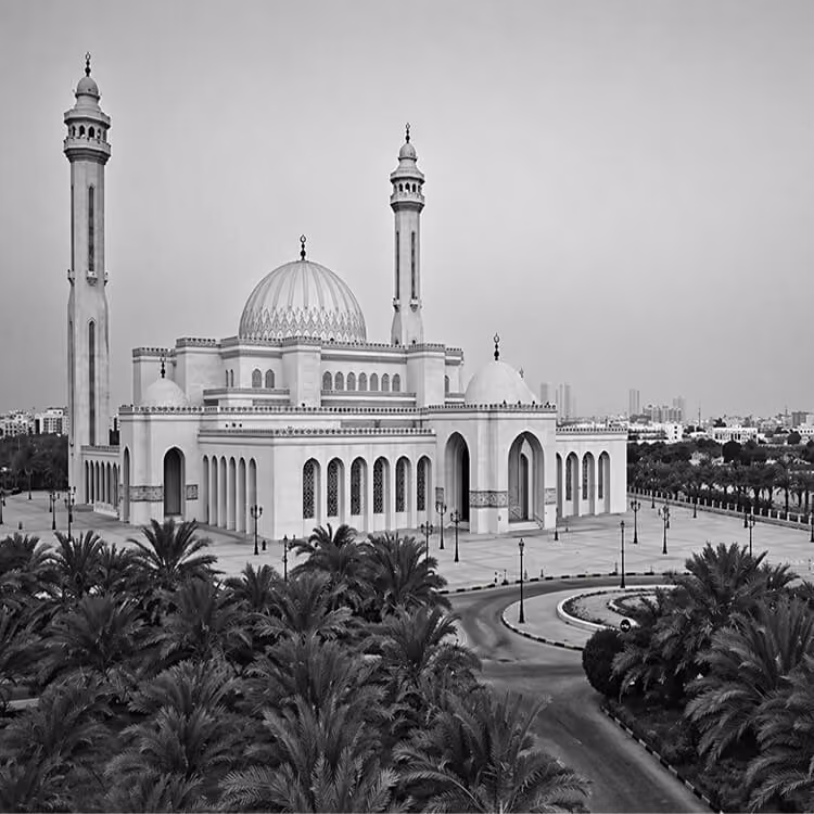Black and white image of Al Fateh Grand Mosque with large dome and minarets surrounded by palm trees in Manama.
