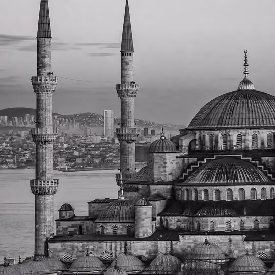 Black and white image of the Blue Mosque with minarets overlooking Istanbul and the Bosphorus.