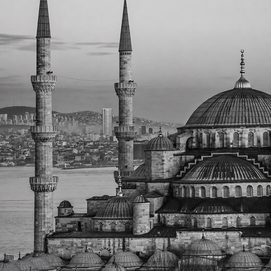Black and white image of the Blue Mosque with minarets overlooking Istanbul and the Bosphorus.