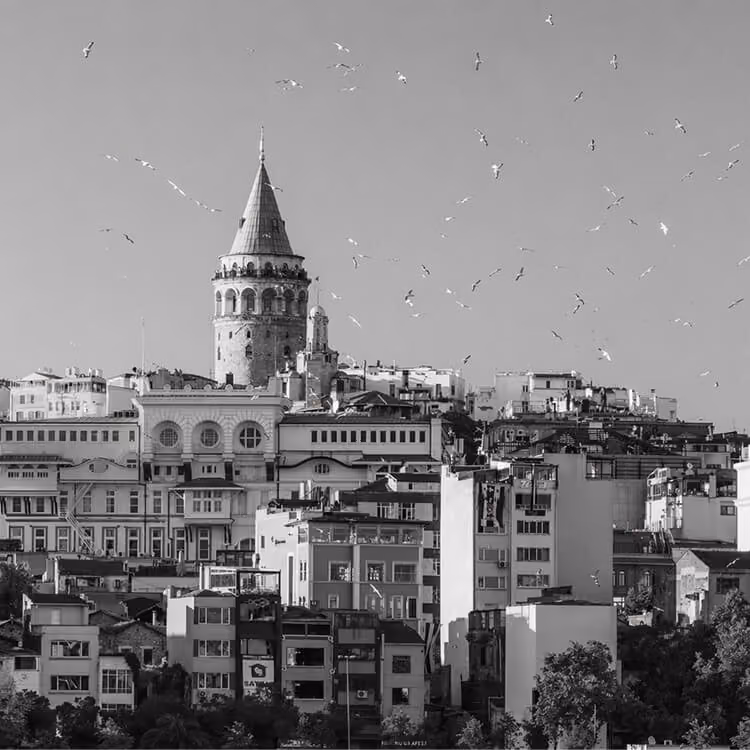 Black and white image of Galata Tower rising above historic buildings in Istanbul.