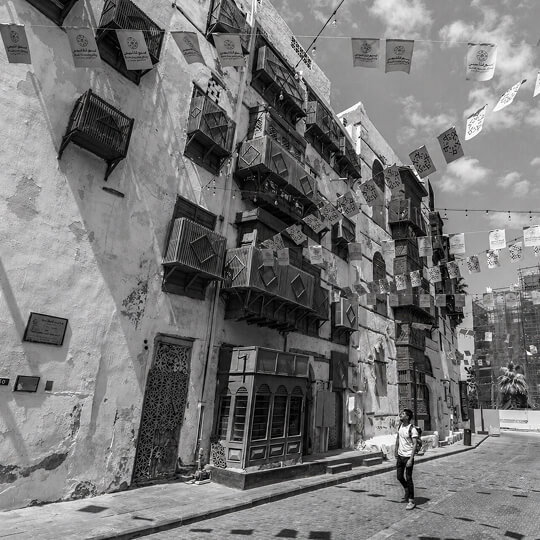 Historic Al-Balad street in Jeddah featuring traditional buildings with wooden balconies and cultural architecture.