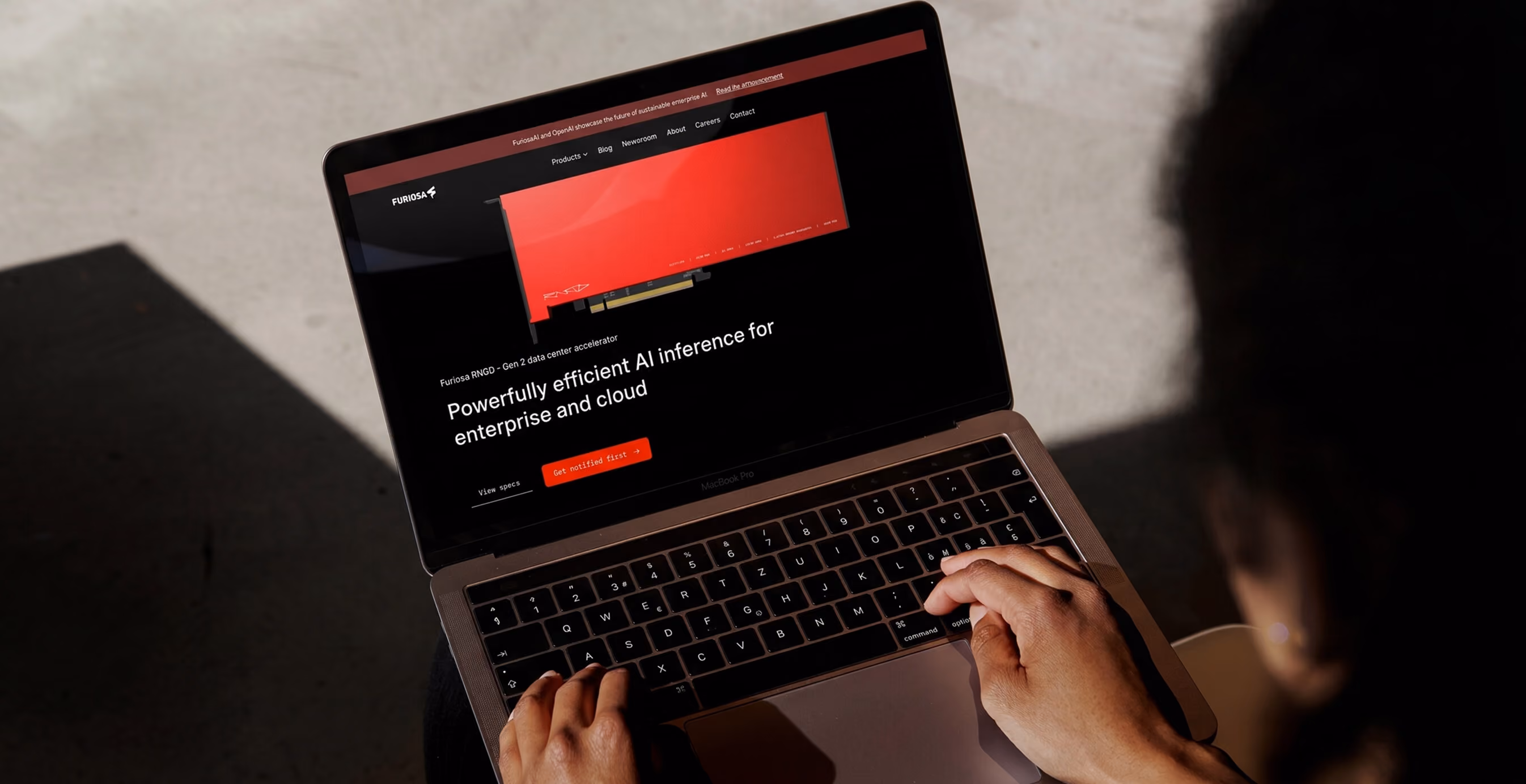 Person using a laptop displaying the Furiosa AI website showcasing an AI inference accelerator for enterprise and cloud.