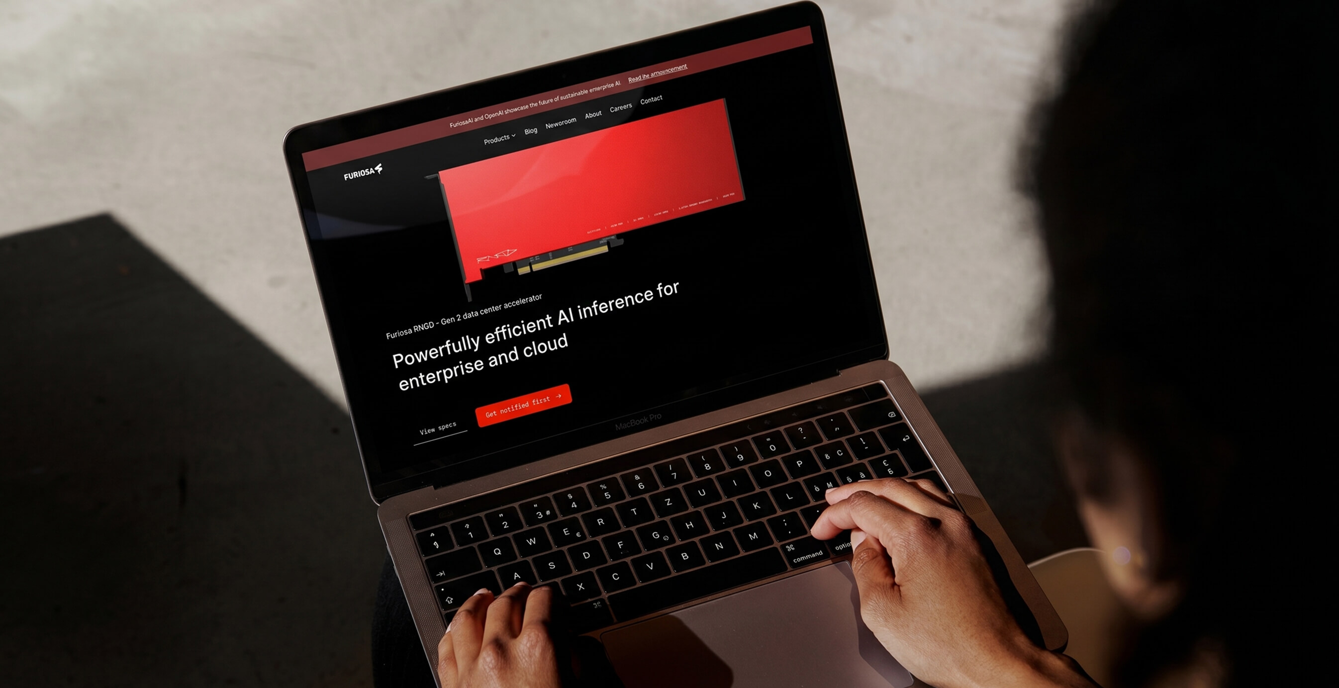 Person using a laptop displaying the Furiosa AI website showcasing an AI inference accelerator for enterprise and cloud.