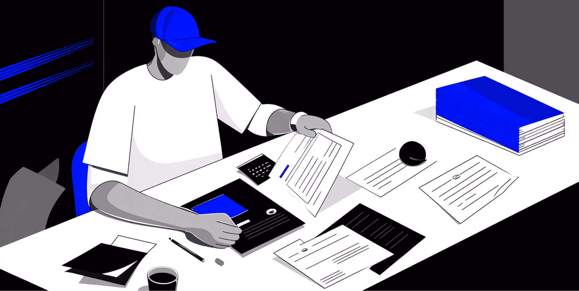 Designer reviewing documents and digital layouts at a desk, representing the logo design process and brand development work.