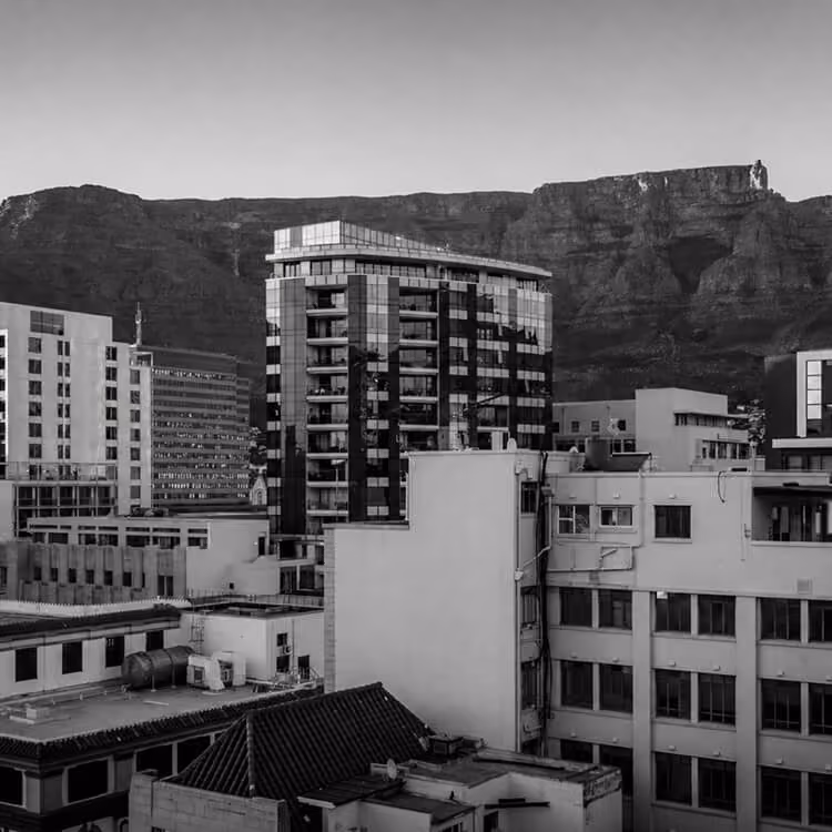 Cape Town city buildings with Table Mountain in the background showcasing urban and natural landscape contrast.