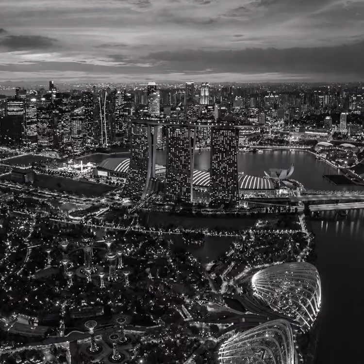 Singapore skyline at night featuring Marina Bay Sands and illuminated waterfront cityscape.