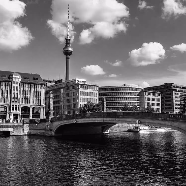 Berlin cityscape with TV Tower and river bridge showcasing historic and modern architecture.