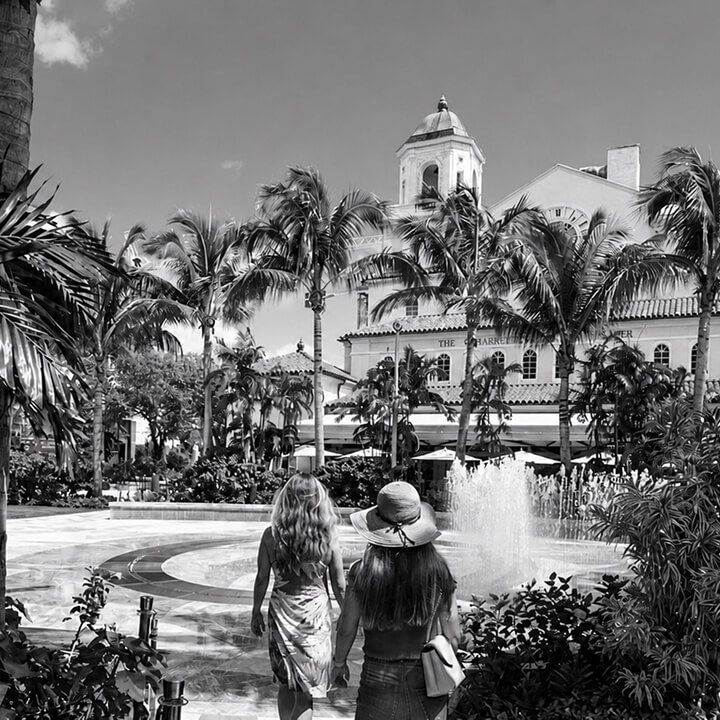 Luxury Florida resort courtyard with palm trees, fountain, and tropical architecture.